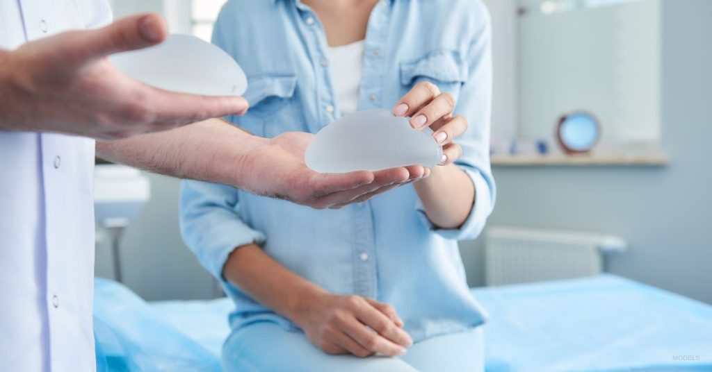 doctor showing patient breast implant options (MODELS)